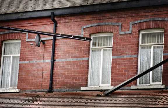 Broken rain gutter on brick building