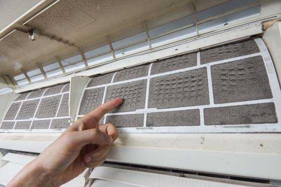 Person pointing at a dirty air conditioner vent. 