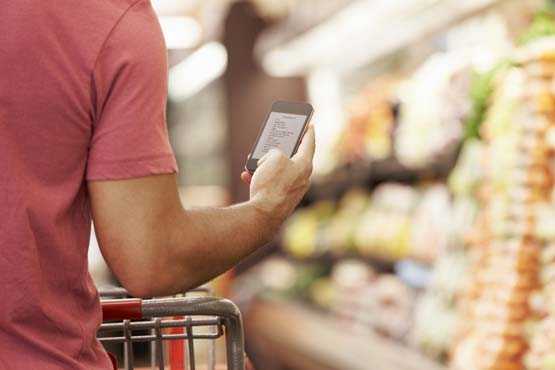 man holding smartphone in grocery store