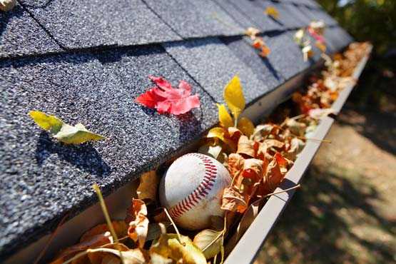 Home’s rain gutters clogged with leaves and a baseball.