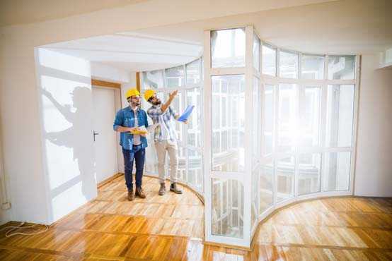 Two men performing a walkthrough at a curved window installation. 