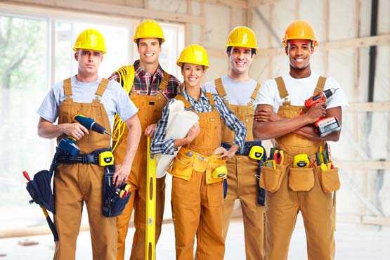 Group of happy multicultural construction workers at a worksite. 