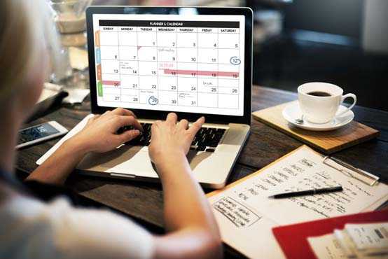 Woman on laptop computer organizing her digital calendar.