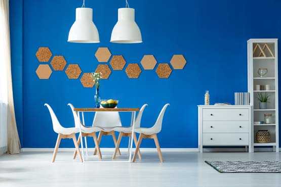 Dining room with white modern furniture and a bright blue accent wall.