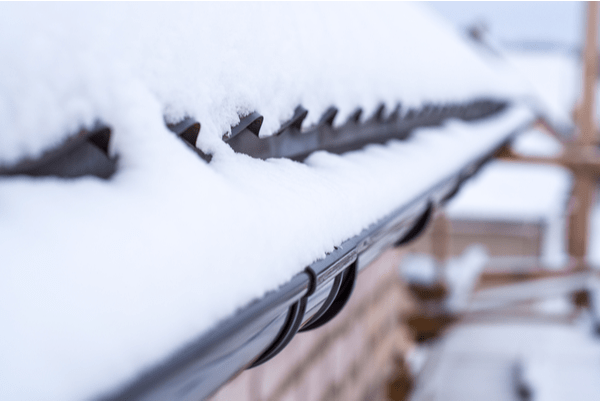 Gutters on house filled with ice and snow during winter.