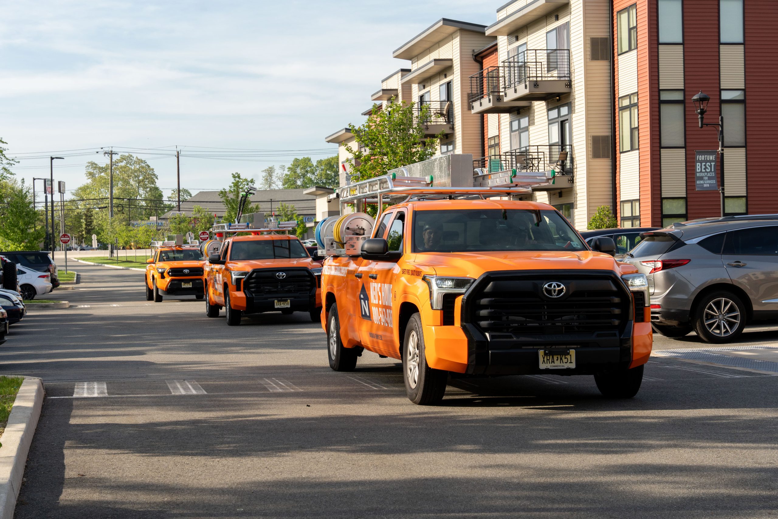 Ned's Home service trucks arriving at a multi-unit residential property.